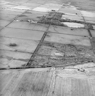 General oblique aerial view looking across the remains of the fort and possible broch towards the country house and farmsteading, taken from the S