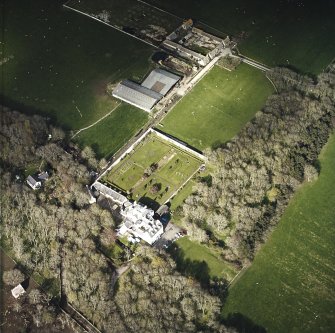 Oblique aerial view centred on the country house and walled garden with the farmsteading adjacent, taken from the SW.