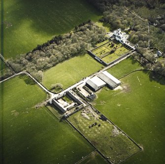 Oblique aerial view centred on the country house and walled garden with the farmsteading adjacent, taken from the NE.