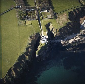 Oblique aerial view centred on the country house, walled gardens and stables, taken from the SSE.