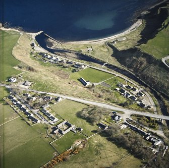 Oblique aerial view of Dunbeath centred on the hall, harbour, fishing station and footbridge, taken from the NNW.