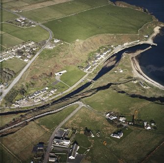 Oblique aerial view of Dunbeath centred on the hall, harbour, fishing station and footbridge, taken from the WSW.