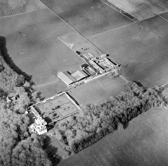 Oblique aerial view centred on the country house and walled garden with the farmsteading adjacent, taken from the SSW.