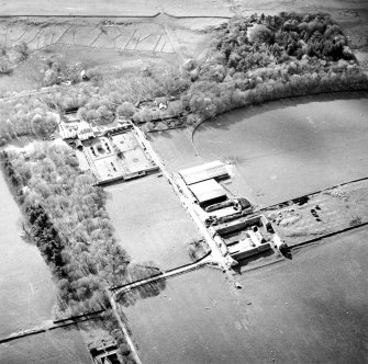 Oblique aerial view centred on the country house and walled garden with the farmsteading adjacent, taken from the ESE.