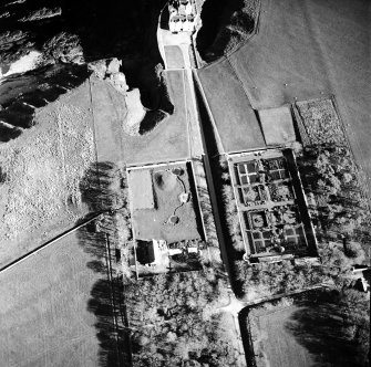 Oblique aerial view centred on the country house, walled gardens and pavilion, taken from the NNW.