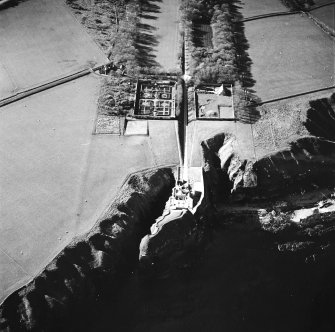 Oblique aerial view centred on the country house, walled gardens and stables, taken from the SE.