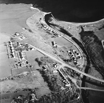 Oblique aerial view of Dunbeath centred on the hall, harbour, fishing station and footbridge with the road bridge adjacent, taken from the NNW.