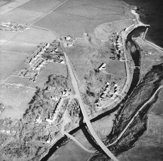 Oblique aerial view of Dunbeath centred on the hall, harbour, fishing station and footbridge with the road bridge adjacent, taken from the WNW.