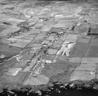 Lybster, oblique aerial view, taken from the SE, showing Lybster village in the centre of the photograph, and the remains of two buildings in the bottom right-hand corner.