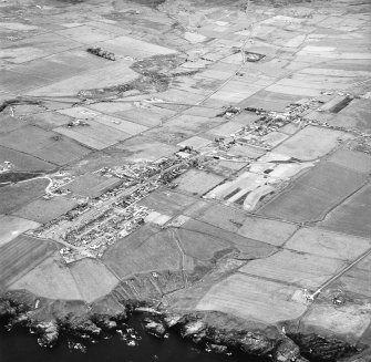 Lybster, oblique aerial view, taken from the SE, showing Lybster village in the centre of the photograph, and the remains of two buildings in the bottom right-hand corner.