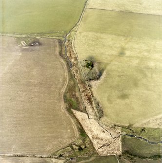 Oblique aerial view centred on the remains of the chapel and graveyard, taken from the SE.