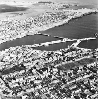 Oblique aerial view centred on the harbour with the town adjacent, taken from the SW.