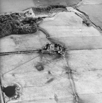 Oblique aerial view centred on the farmsteading with the country house and the remains of the chapel and graveyard adjacent, taken from the NW.