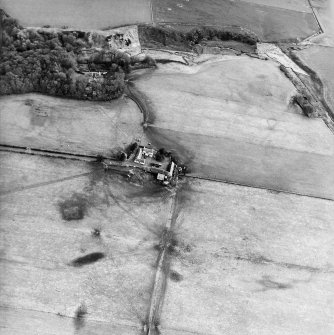 Oblique aerial view centred on the farmsteading with the country house and the remains of the chapel and graveyard adjacent, taken from the NW.