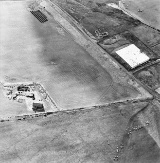 Oblique aerial view of the reservoir and the remains of the buildings, farmstead and chambered cairn, taken from the N.