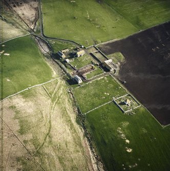 Oblique aerial view centred on the farmstead and mausoleum, taken from the SW.