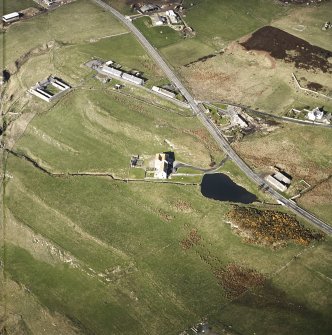 Oblique aerial view centred on the watermill with the farmsteads, house, curing yard and council houses, taken from the ENE.