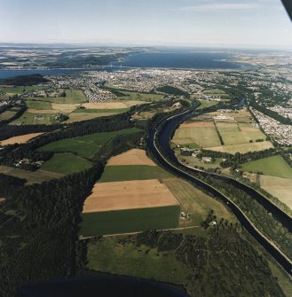 General oblique aerial view looking across the Caledonian Canal and Inverness towards the road bridge and the Moray Firth, taken from the SW.