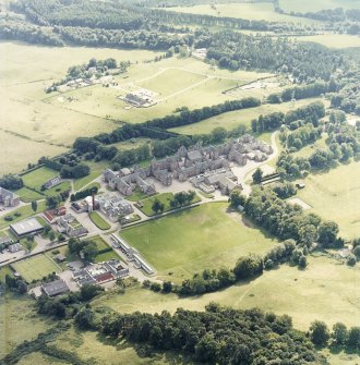 Oblique aerial view centred on the hospital and churches, with the farmsteading adjacent, taken from the NNW.