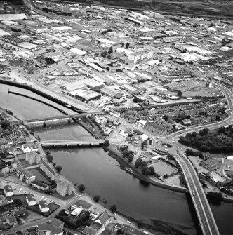 General oblique aerial view of the town, centred on the road bridges and sawmill, taken from the WSW.