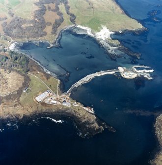 Oblique aerial view centred on the construction of the new pier, with harbour, pier and fish traps adjacent, taken from the S.