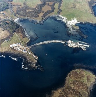 Oblique aerial view centred on the construction of the new pier, with harbour, pier and fish traps adjacent, taken from the SSE.