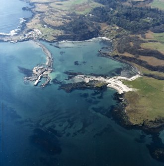 Oblique aerial view centred on the construction of the new pier, with harbour, pier and fish traps adjacent, taken from the NE.