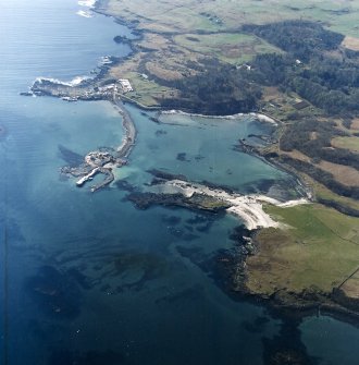 Oblique aerial view centred on the construction of the new pier, with harbour, pier and fish traps adjacent, taken from the NE.