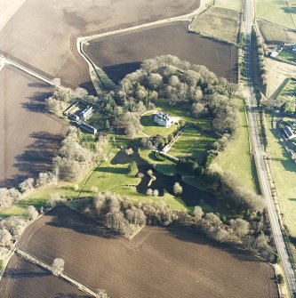 Oblique aerial view centred on the country house, farmhouse and stables taken from the WNW.