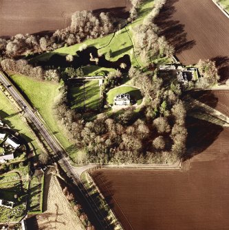 Oblique aerial view centred on the country house, farmhouse and stables taken from the SE.