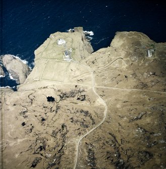 Oblique aerial view centred on the lighthouse, keepers' cottages, cottages and support buildings with the radar station adjacent, taken from the SW.
