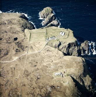 Oblique aerial view centred on the lighthouse, keepers' cottages, cottages and support buildings with the radar station adjacent, taken from the SE.