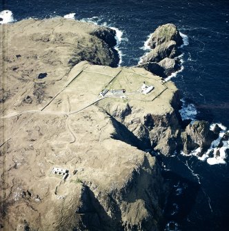 Oblique aerial view centred on the lighthouse, keepers' cottages, cottages and support buildings with the radar station adjacent, taken from the ESE.