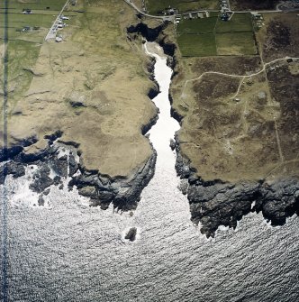 Oblique aerial view centred on the Smoo cave with the remains of the radar station and crofting townships adjacent, taken from the NE.