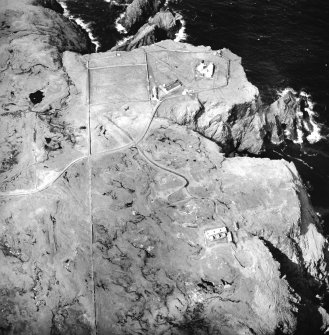 Oblique aerial view centred on the lighthouse, keepers' cottages, cottages and support buildings with the radar station adjacent, taken from the SE.
