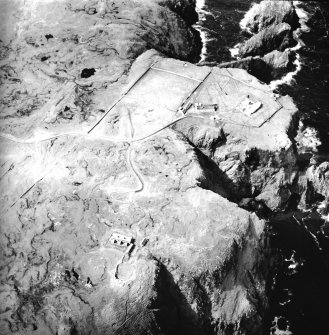 Oblique aerial view centred on the lighthouse, keepers' cottages, cottages and support buildings with the radar station adjacent, taken from the ESE.