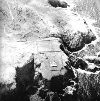 Oblique aerial view centred on the lighthouse, keepers' cottages, cottages and support buildings, taken from the NE.