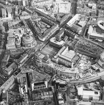 Oblique aerial view of Edinburgh centred on the Clydesdale Bank Plaza and construction of Exchange Crescent, taken from the NW.