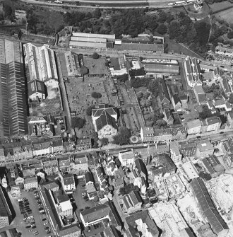Oblique aerial view centred on the church and graveyard, taken from the S.