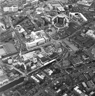 Oblique aerial view centred on the brewery with the canal, canal basin and canal bridge adjacent, taken from the SSW.