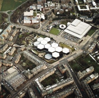 Oblique aerial view centred on the offices with the swimming pool, school, burial ground, halls of residence and church adjacent, taken from the WNW.