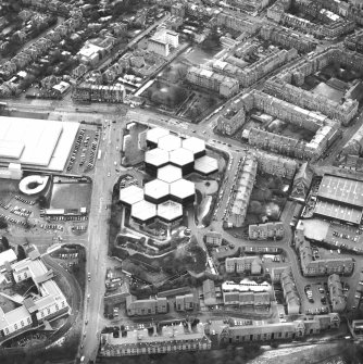 Oblique aerial view centred on the offices with the school, burial ground and church adjacent, taken from the NE.