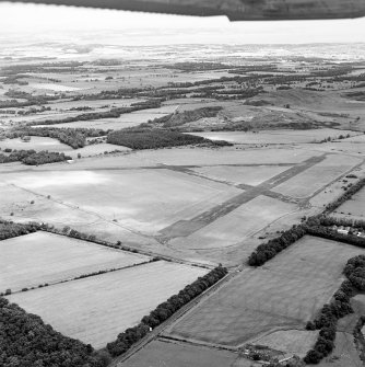 Oblique aerial view of Kirknewton Airfield centred on the airfield with Dalmahoy Hill fort and Kaimes Hill fort and quarry adjacent, taken from the S.