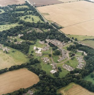 General oblique aerial view centred on the hospital before development and house, taken from the ESE.
