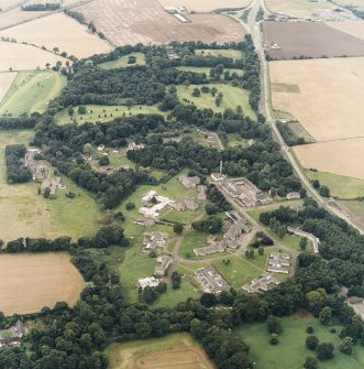 General oblique aerial view centred on the hospital before development and house, taken from the E.