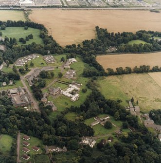 Oblique aerial view centred on the hospital before development and house, taken from the WSW.
