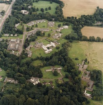Oblique aerial view centred on the hospital before development and house, taken from the SW.