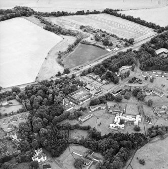Oblique aerial view centred on the hospital before development and house, taken from the SSW.