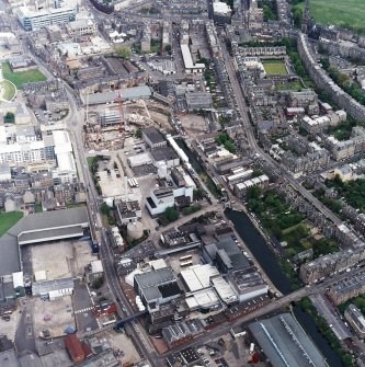 Oblique aerial view centred on the brewery with the leisure centre and cinema, canal, canal basin and canal bridge adjacent, taken from the W.