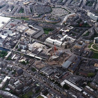 Oblique aerial view centred on the brewery with the canal, canal basin and canal bridge adjacent, taken from the SE.